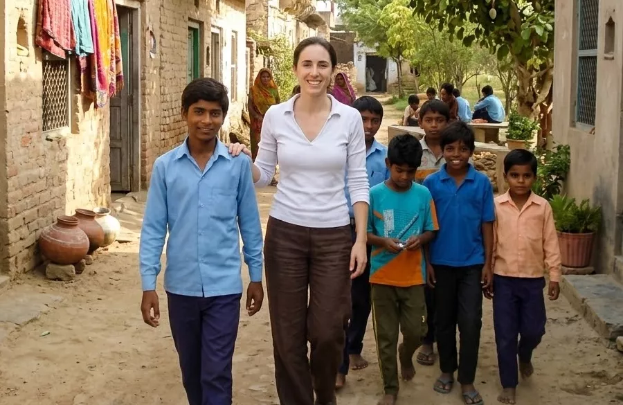 Volunteer walking through village street with local coordinator