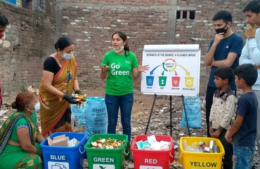 Volunteer explaining waste segregation and cleanliness to villagers