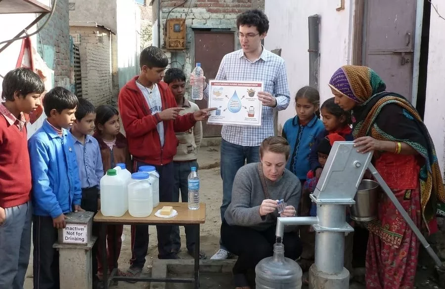 Volunteers checking water source and discussing safe water practices